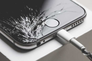 画面割れたiPhoneがテーブル上